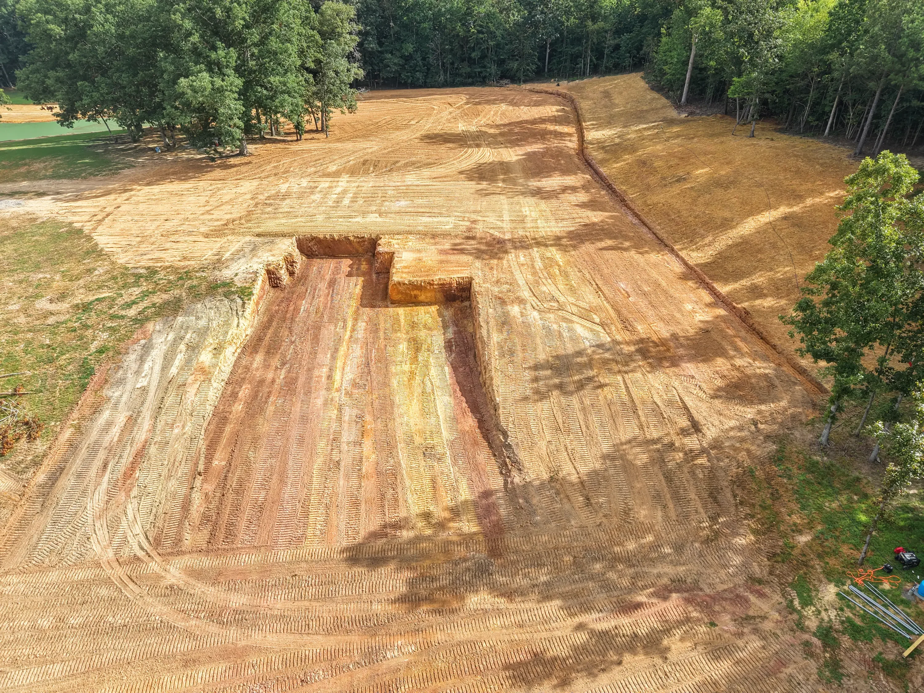 Aerial view of excavated site with trenches, graded earth, and directional cuts